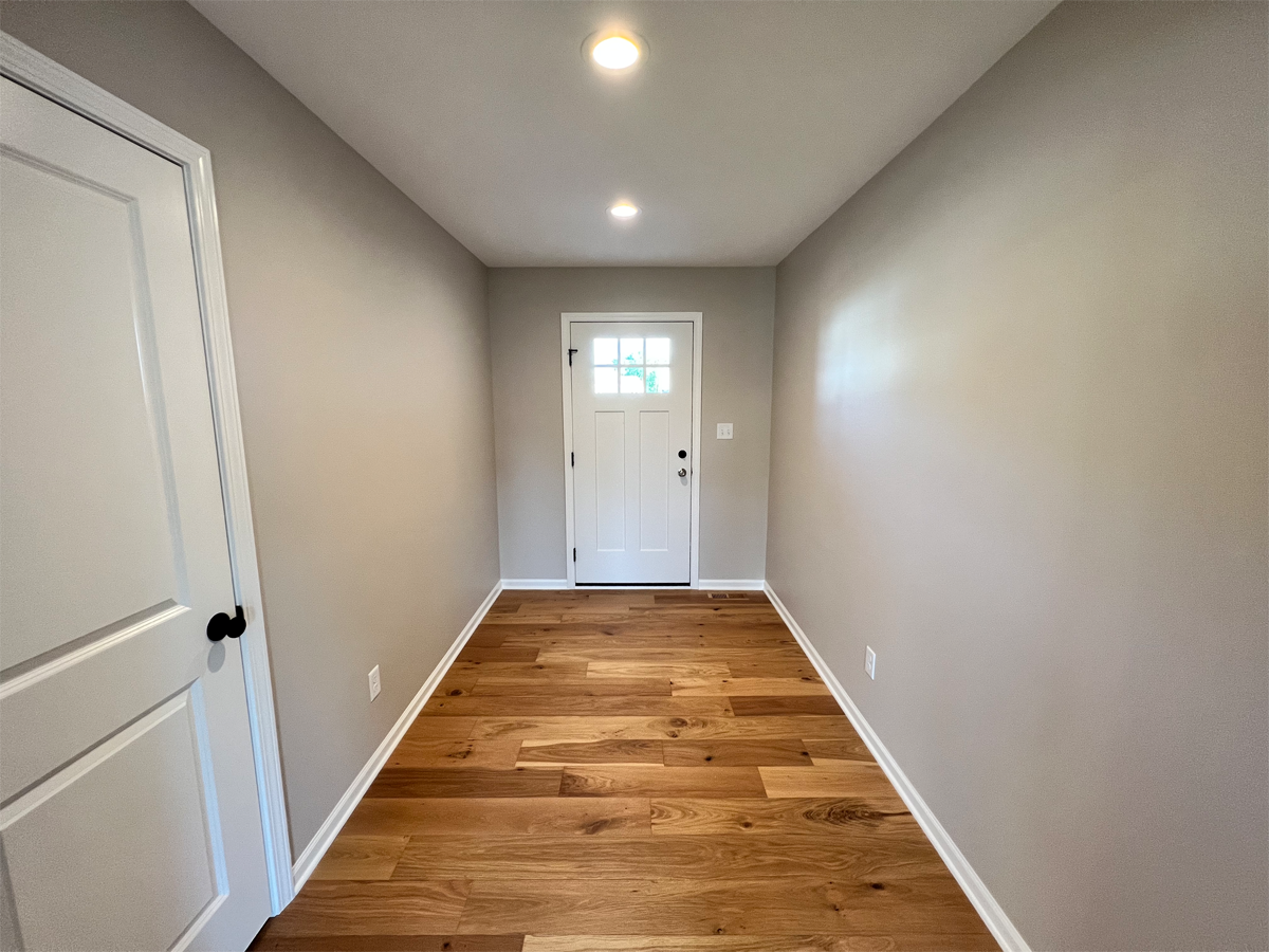 The Franklin entry way with white door and hardwood floors