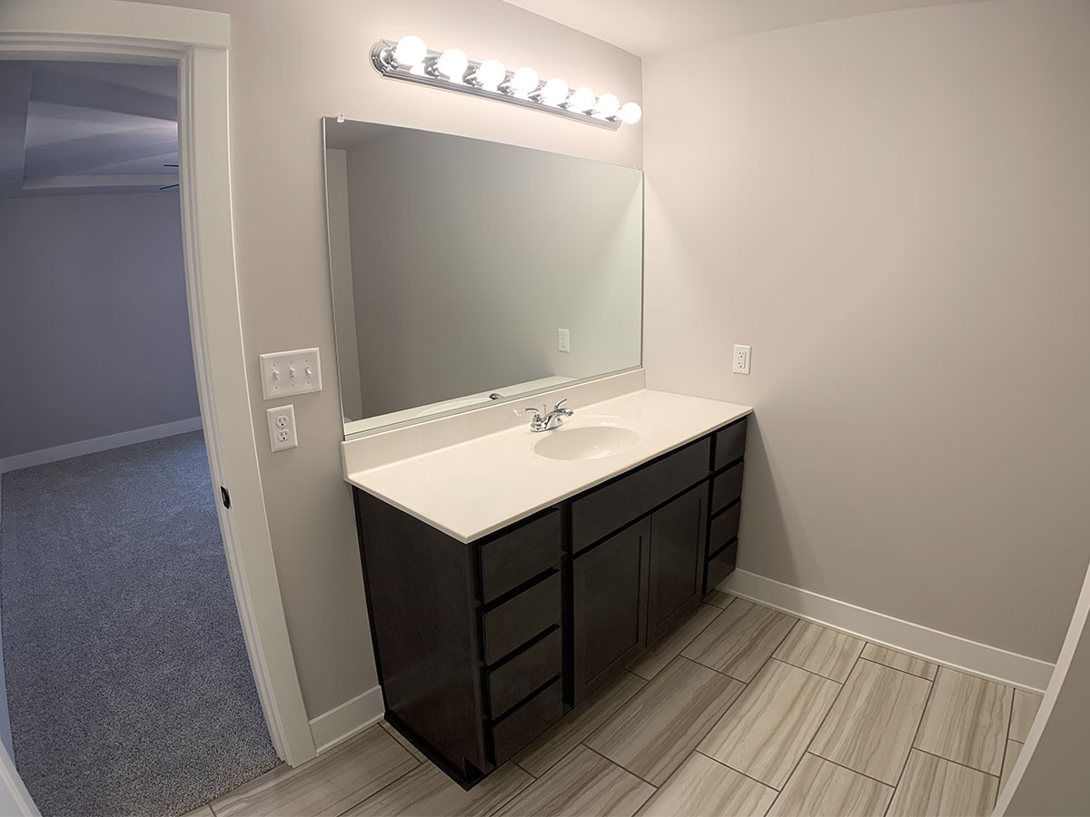 Master bathroom with sink, tile floor, and large mirror