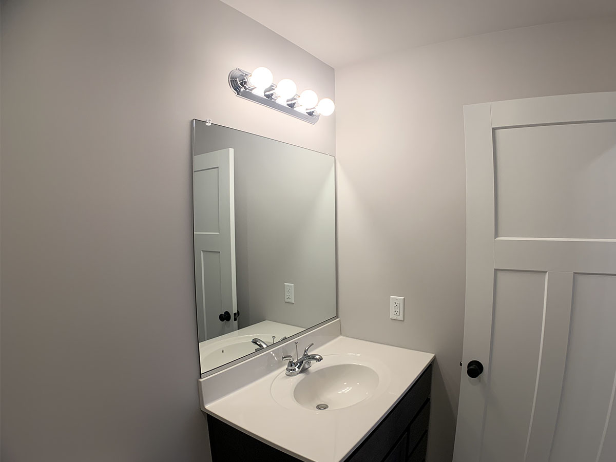 Upper level bathroom with sink and small mirror