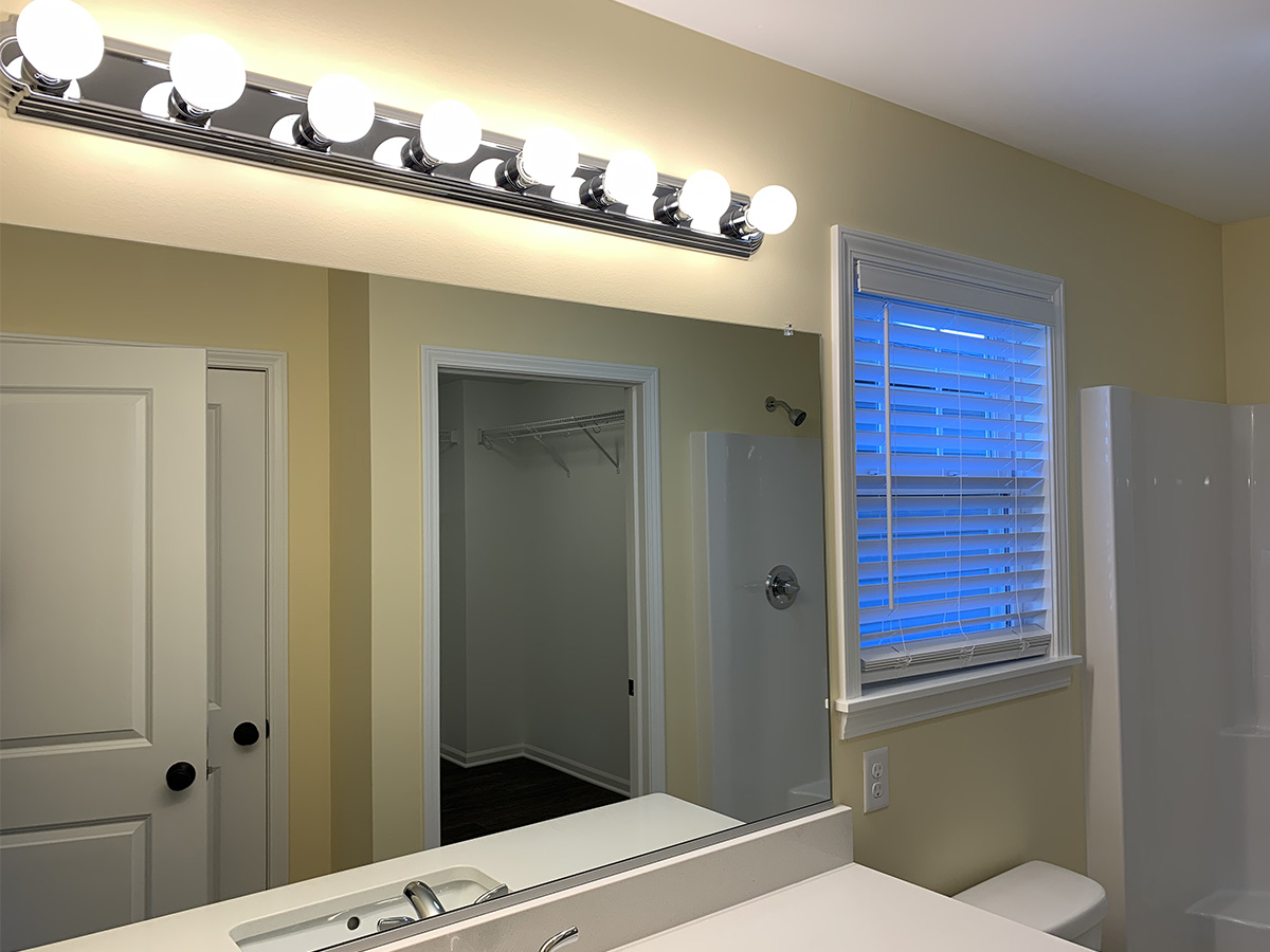 Master bathroom with sink, mirror, and bulb lights