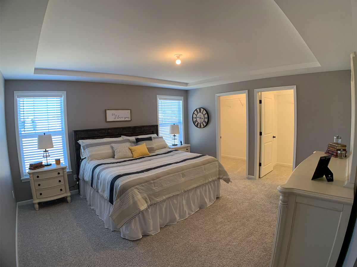 Master bedroom with closet, bathroom, and box ceiling