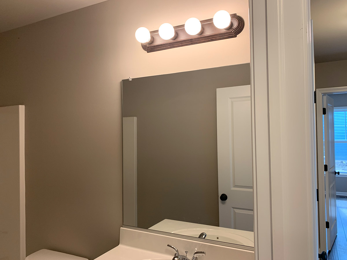 The Stockton bathroom with small mirror and multi-bulb lights
