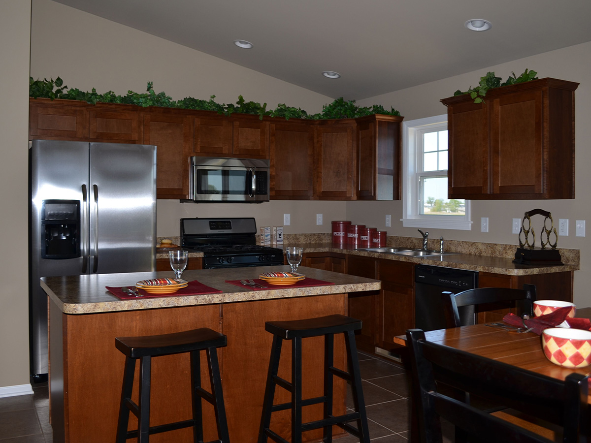 The Wolcott kitchen with granite counter tops, mahogany cabinets, and kitchen table