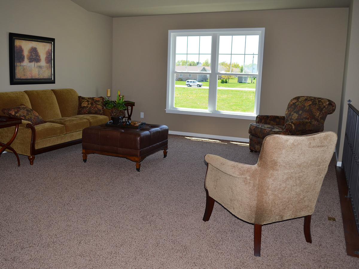 The Wolcott living room with furniture and double hung windows