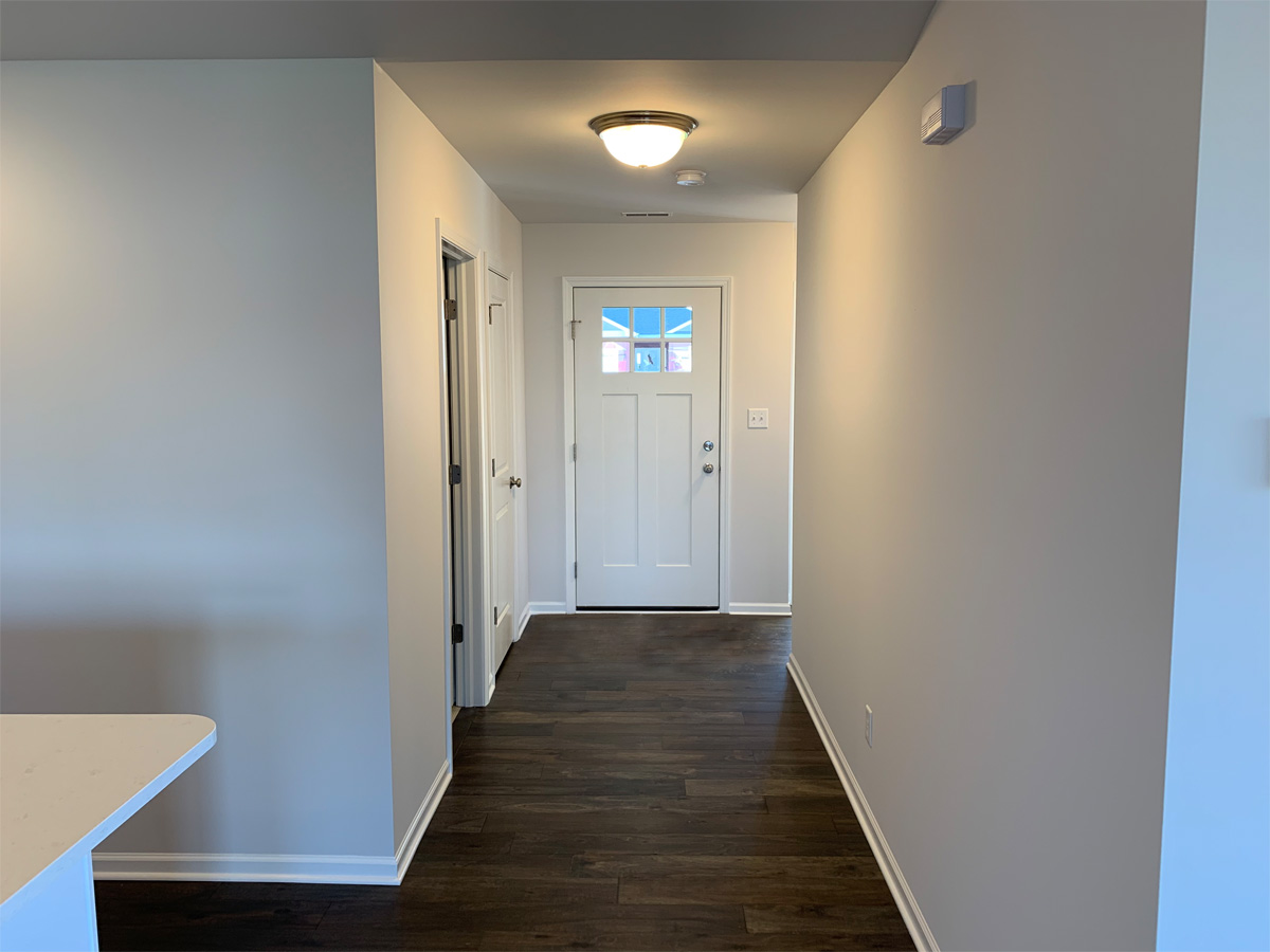 The Churchill entry way with hardwood floors and white exterior door