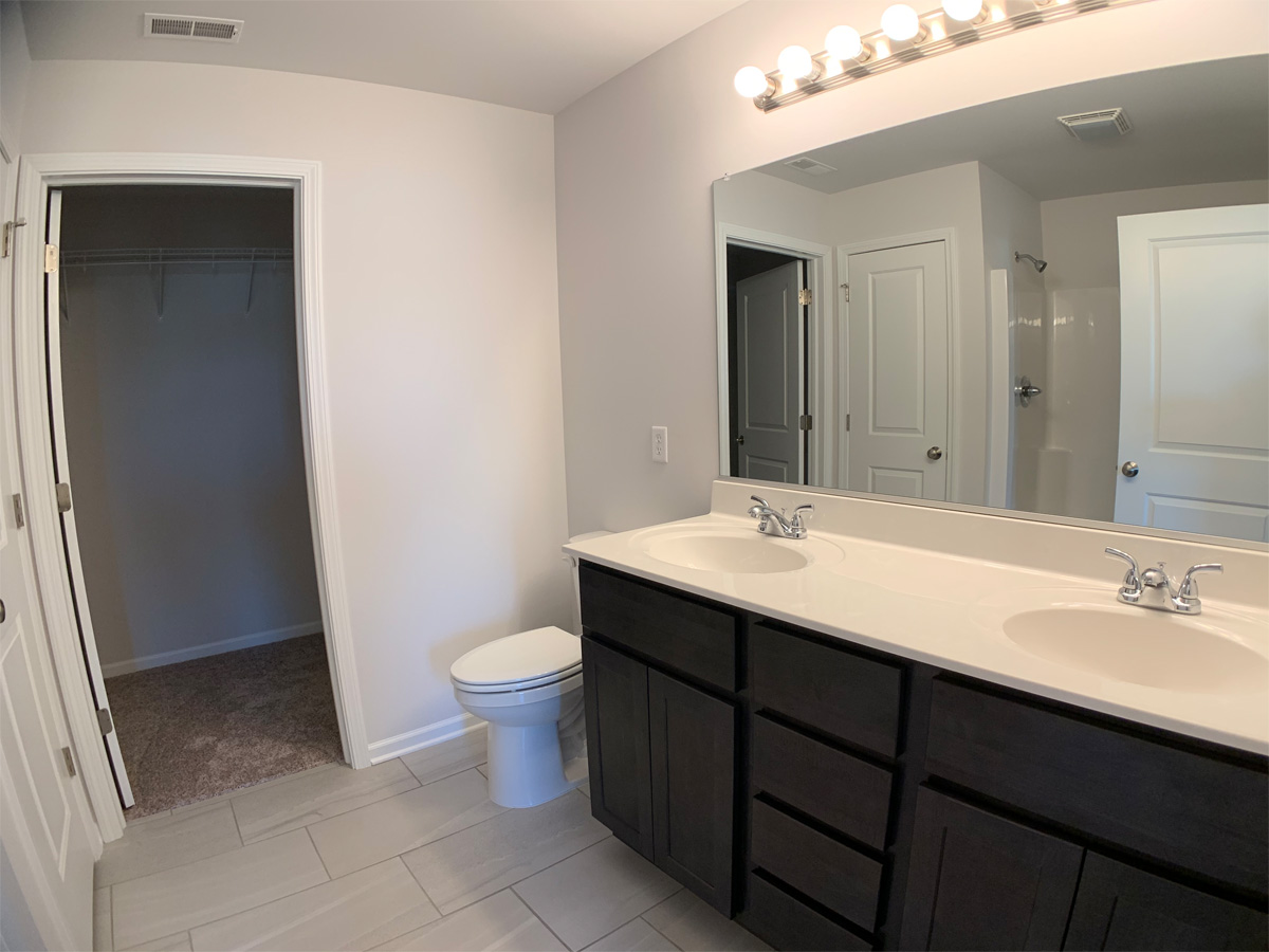 The Churchill master bathroom with vanity, toiler and walk in closet
