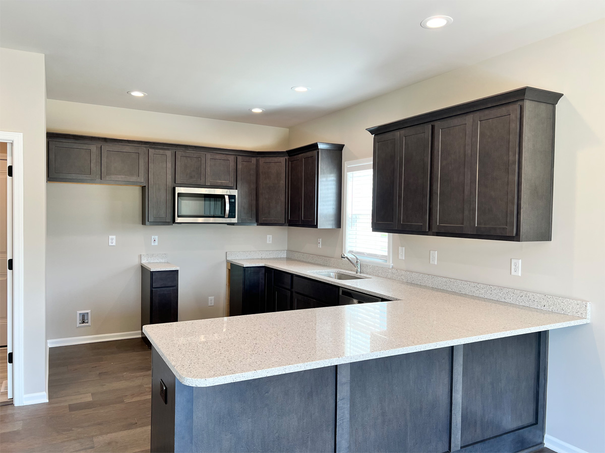 The Middleton kitchen with dark wood cabinets, granite countertops and appliances