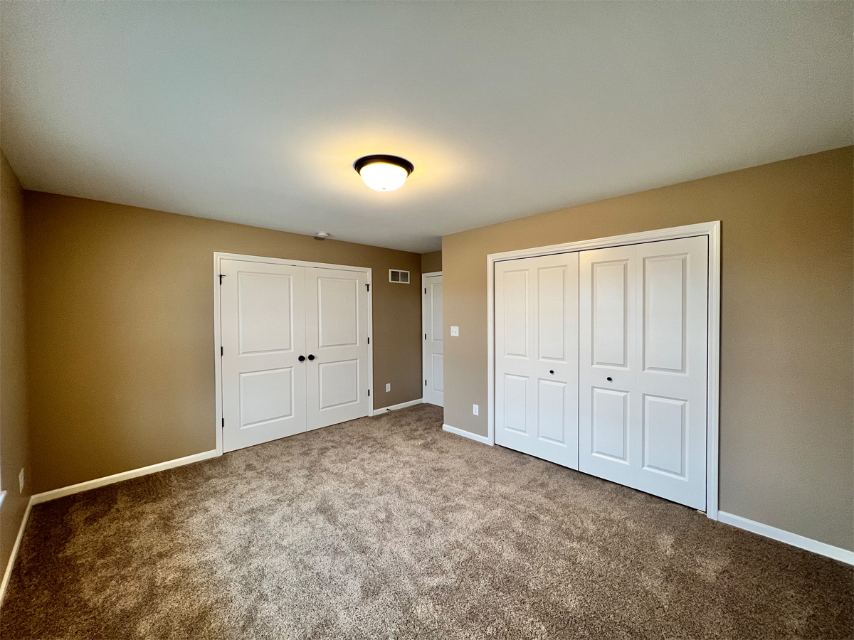 The Redbud second bedroom with carpet, closet and french doors