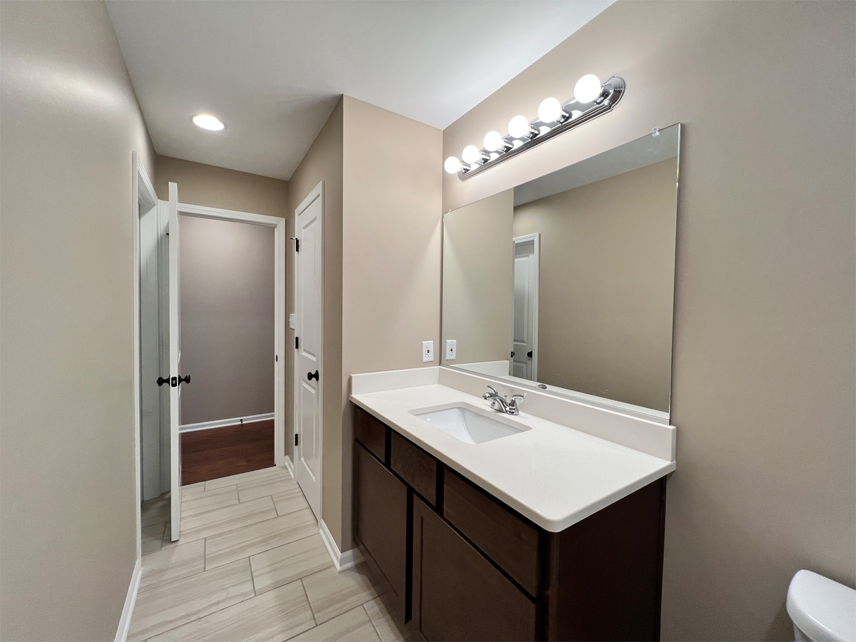 The Redbud main bathroom with vanity and ceramic floors