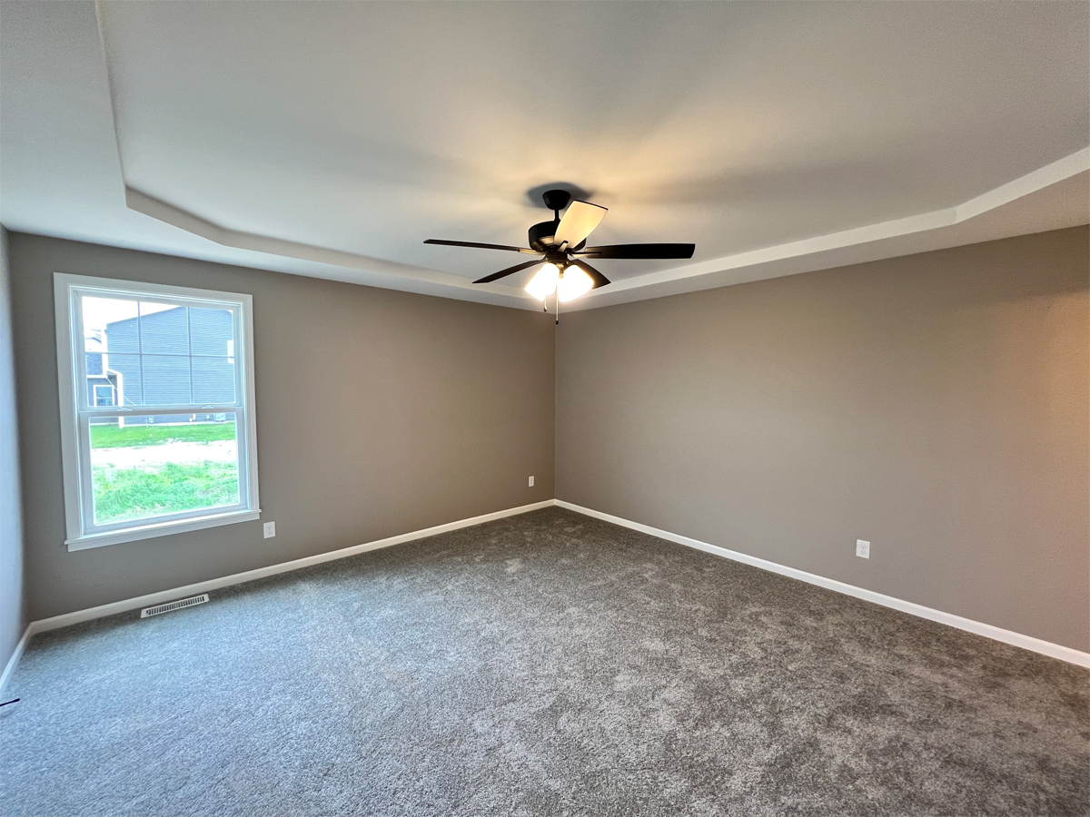 The Revere master bedroom with boxed ceiling and ceiling fan