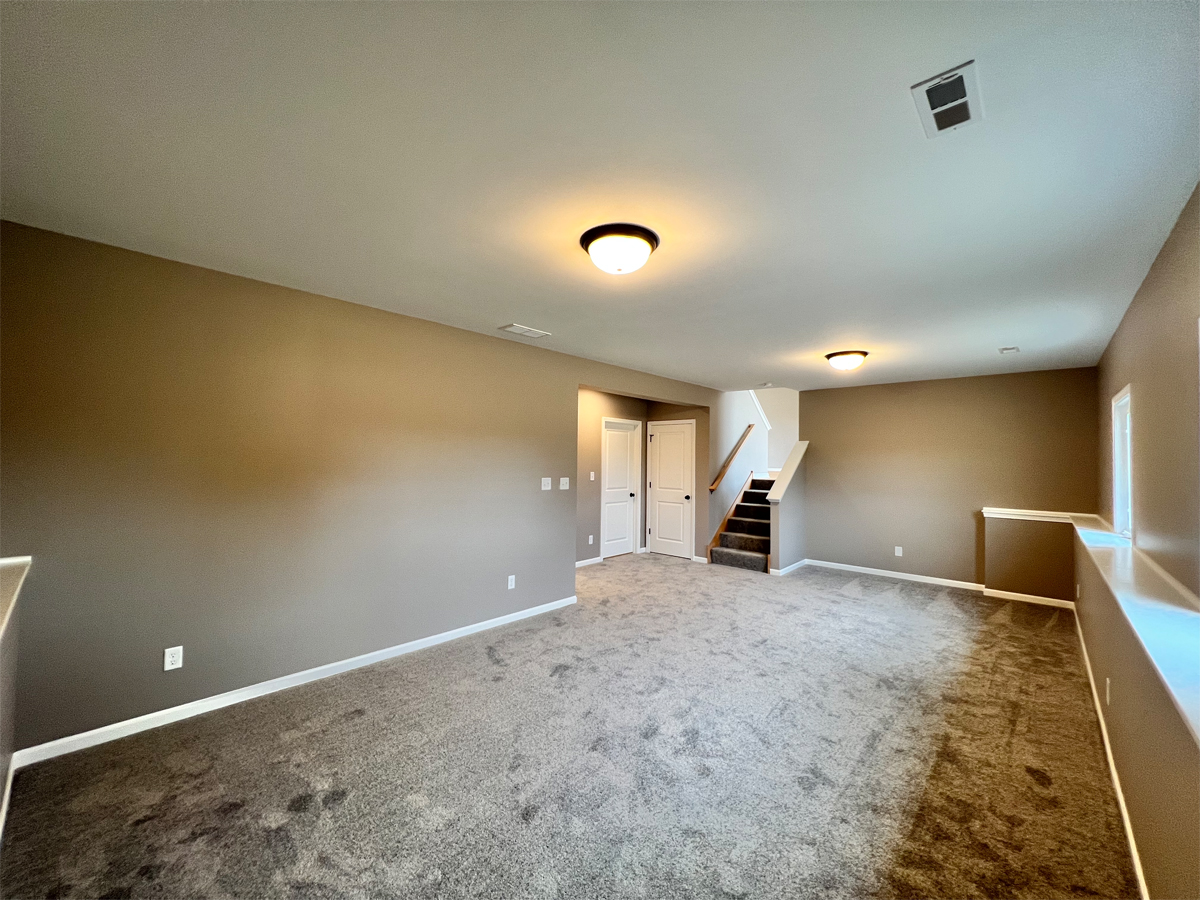 The Revere lower level family room with carpet and ledge