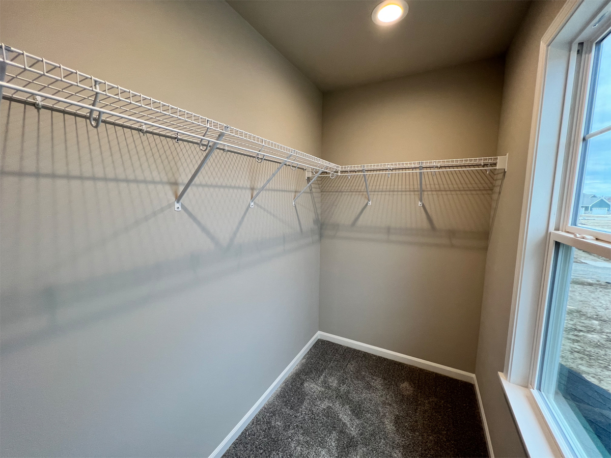 The Washington second bedroom walk in closet with window and wire shelving