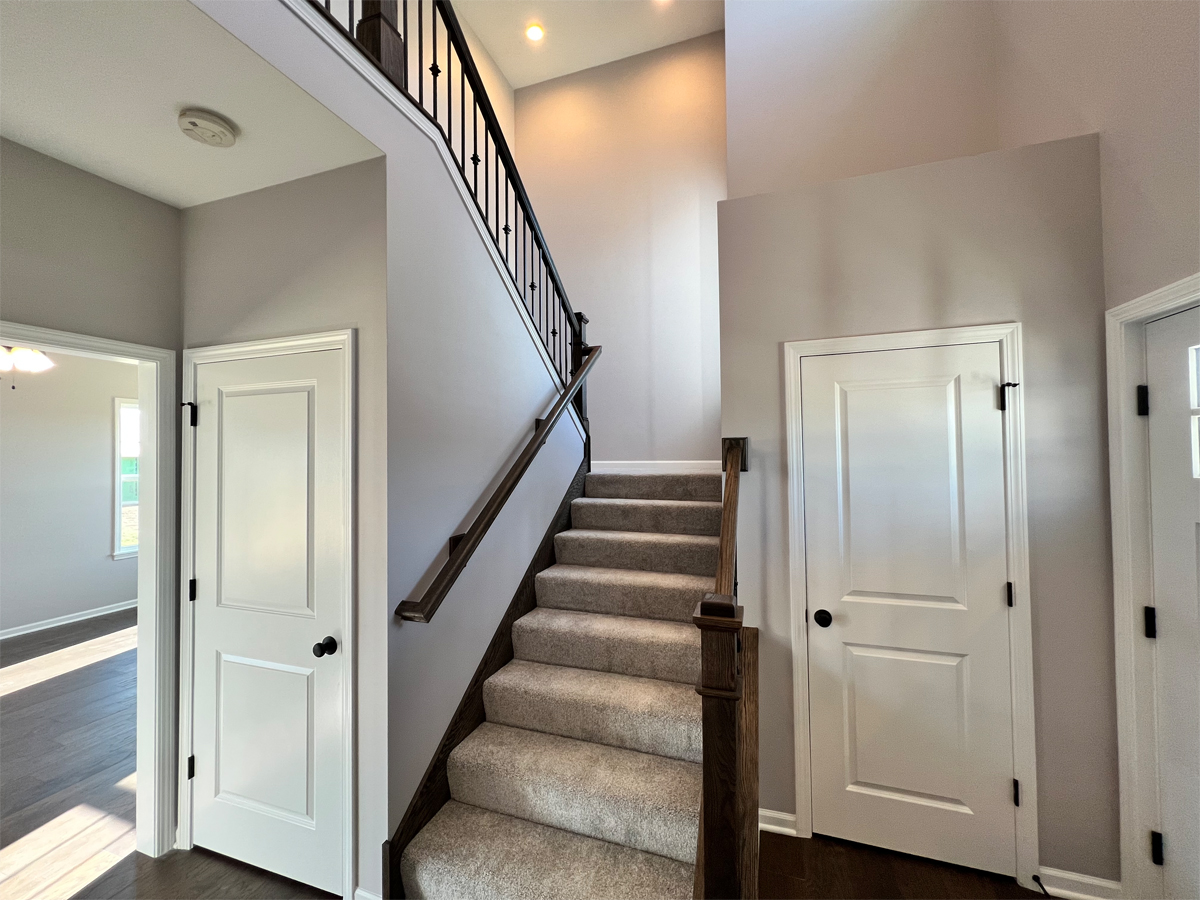 The Adams entry way with white doors, hardwood, stairs