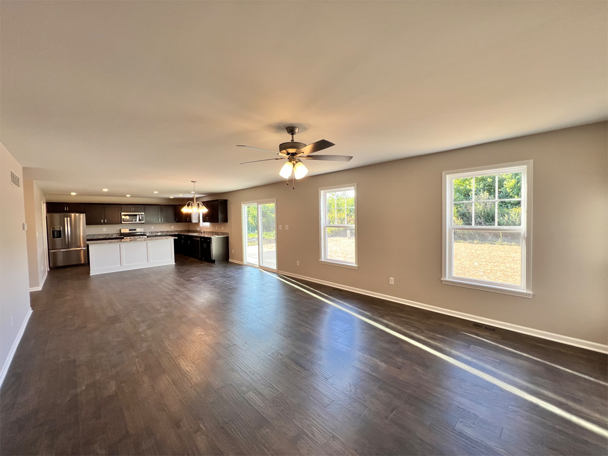 The Sherman living room with hardwood floors, ceiling fan, windows