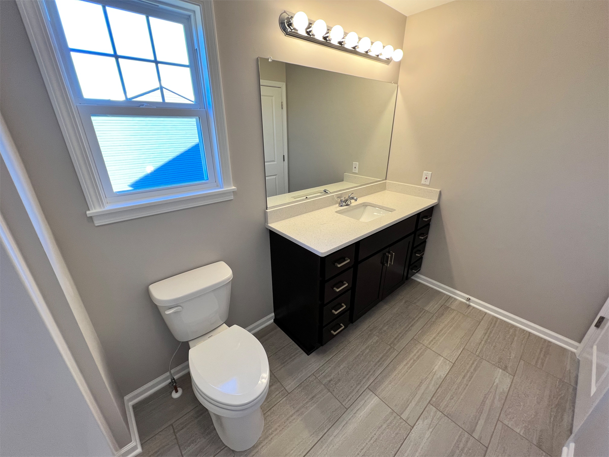 The Sherman master bathroom with ceramic floors, vanity and toilet
