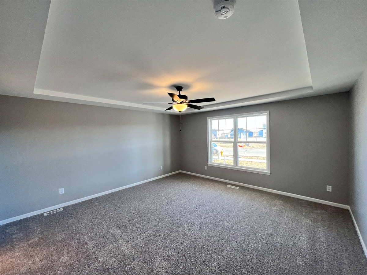 Juniper master bedroom with carpet, ceiling fan and window