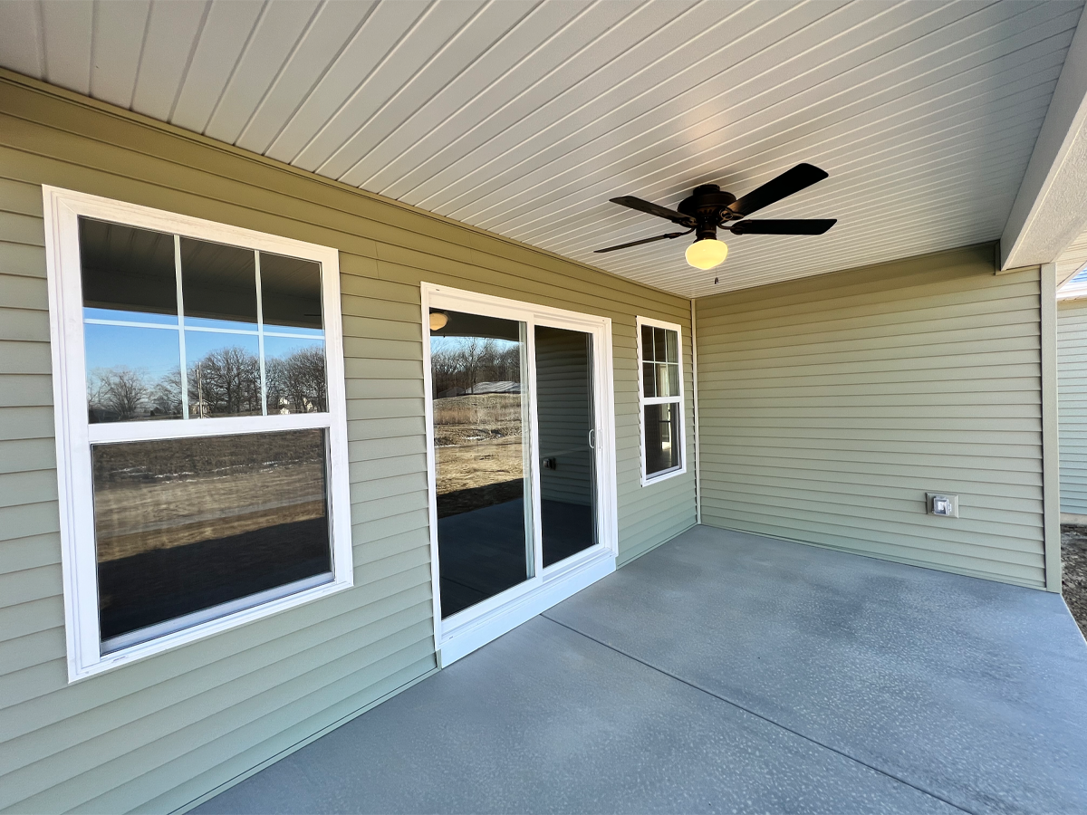 Juniper covered back porch with patio door, ceiling fan and concrete floors