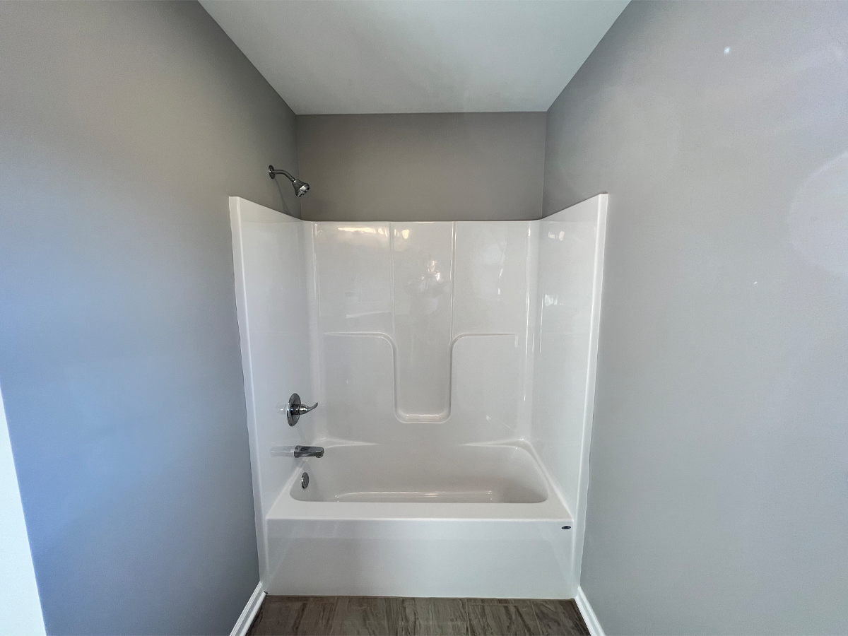 Juniper main bathroom with fiberglass shower and ceramic floors