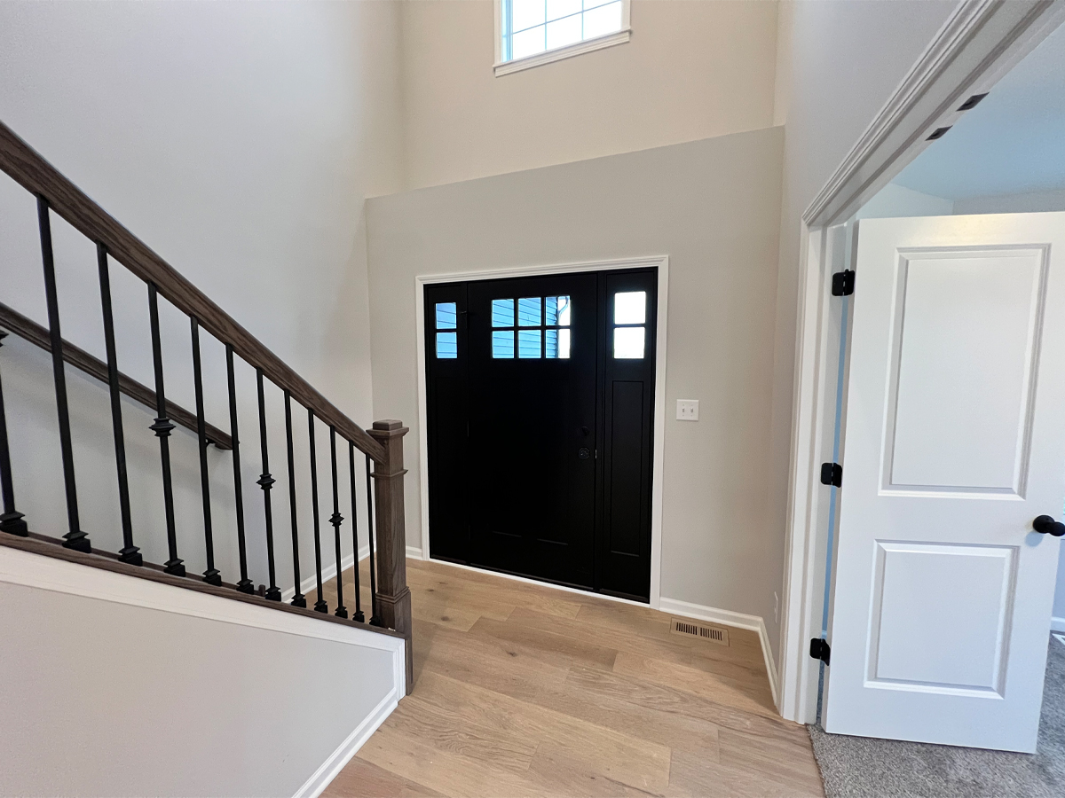 The Walton entry with black door and hardwood