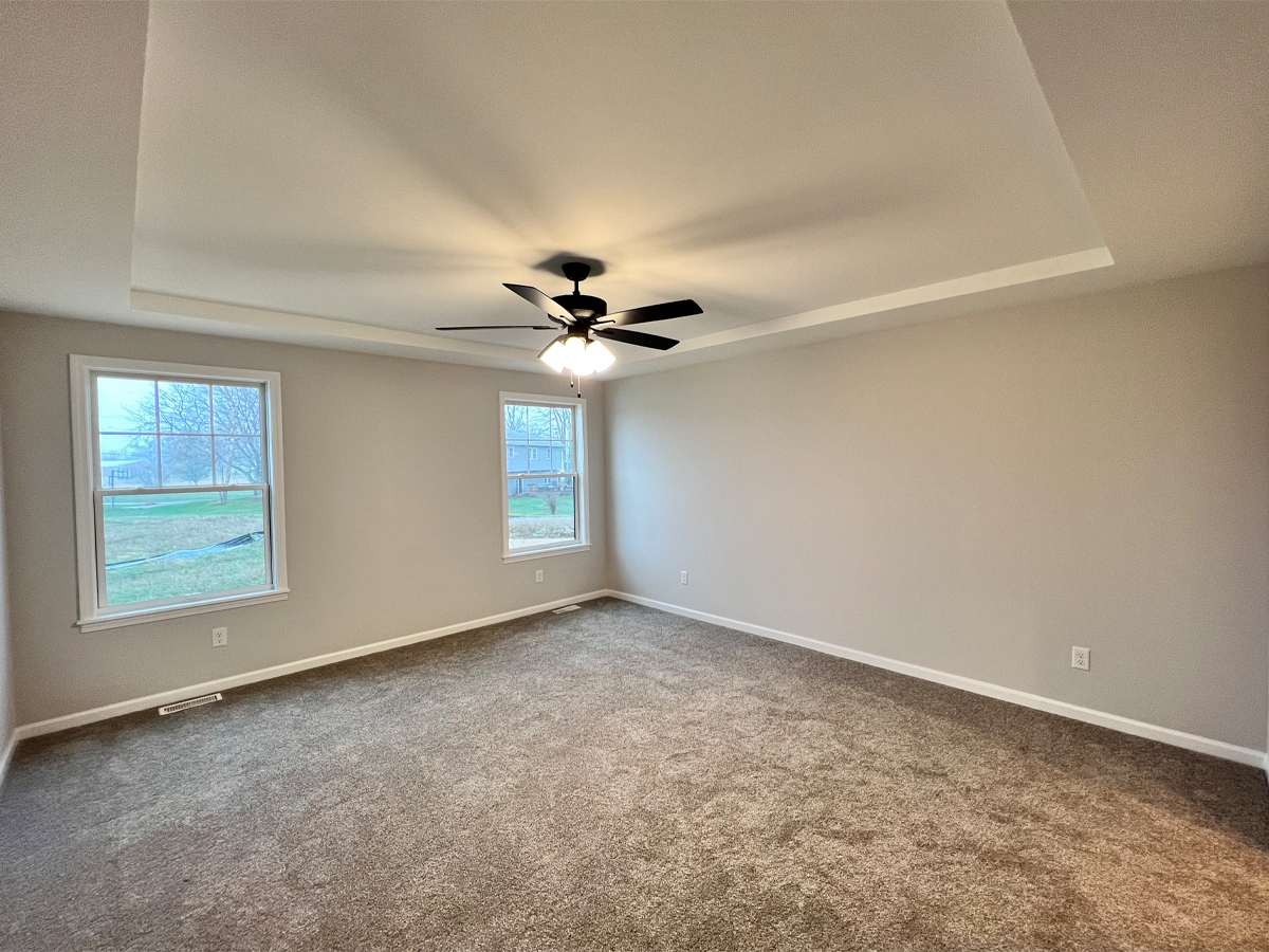 The Walton master bedroom with carpet, ceiling fan and windows