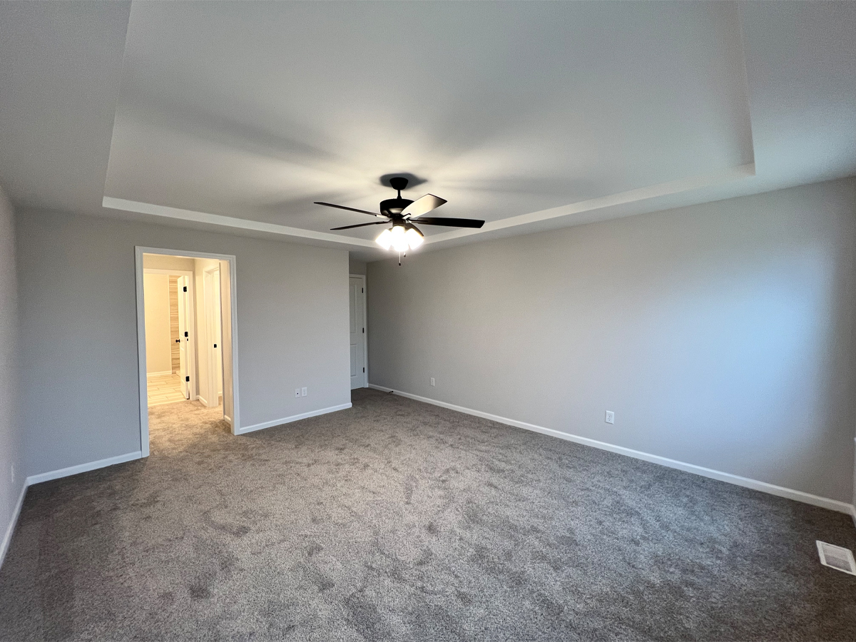 The Walton master bedroom with carpet, ceiling fan and access to master bathroom