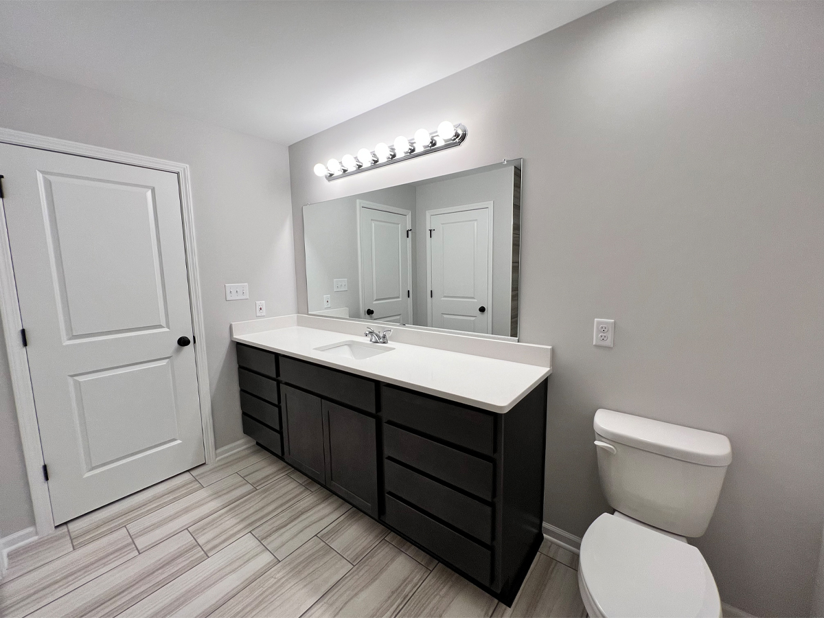 The Walton master bathroom with large vanity, toilet, and ceramic floors